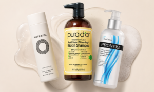 PURA D’OR, Nutrafol, and HairGenics Pronexa biotin shampoos arranged on a soft beige background with shampoo foam