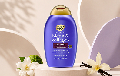 OGX Thick & Full Biotin & Collagen shampoo bottle on a minimalist pastel studio set with vanilla flowers, bergamot accents, and soft curved backdrop shapes.